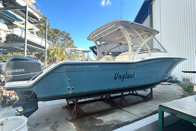 Slide: The Image of 2020 Grady-White Freedom 325 boat on stand, blue hull, Yamaha engine visible. - 9
