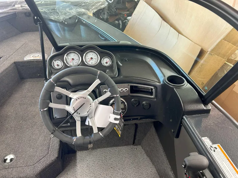 Slide: The Image of 2025 Lund 1875 Crossover XS boat dashboard with steering wheel and gauges. - 5