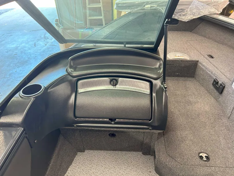 Slide: The Image of 2025 Lund 1875 Crossover XS interior, featuring storage compartment and carpeted flooring. - 6