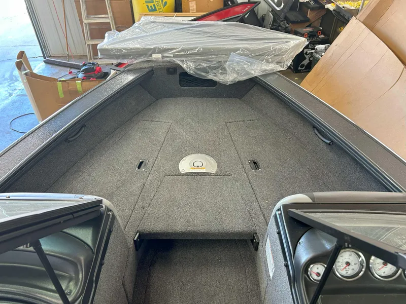 Slide: The Image of 2025 Lund 1875 Crossover XS boat interior with gray carpet and dashboard view. - 8