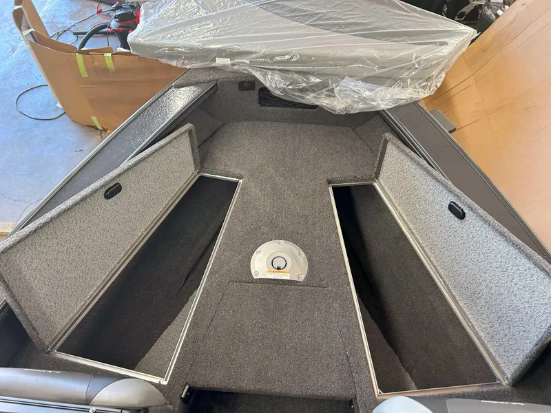 Slide: The Image of 2025 Lund 1875 Crossover XS boat interior with open storage compartments. - 9