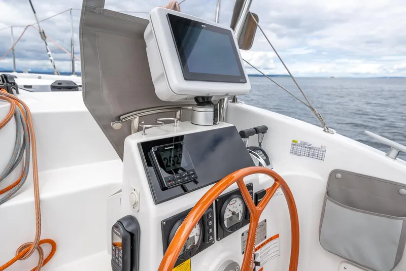 Slide: The Image of Helm of 2025 Excess 11 sailboat with navigation equipment and wooden steering wheel. - 10