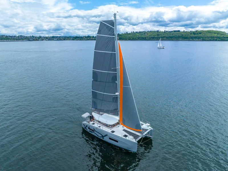 Slide: The Image of Sailing catamaran Excess 11, 2025 model, on calm waters under a cloudy sky. - 4