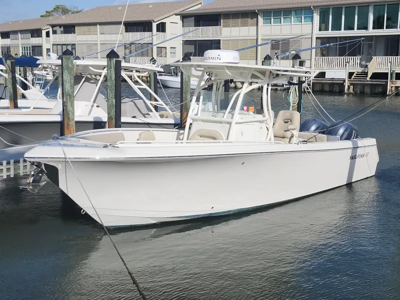 The Image of 2018 Sailfish 270 CC boat docked in marina, featuring sleek design and twin engines. - 0