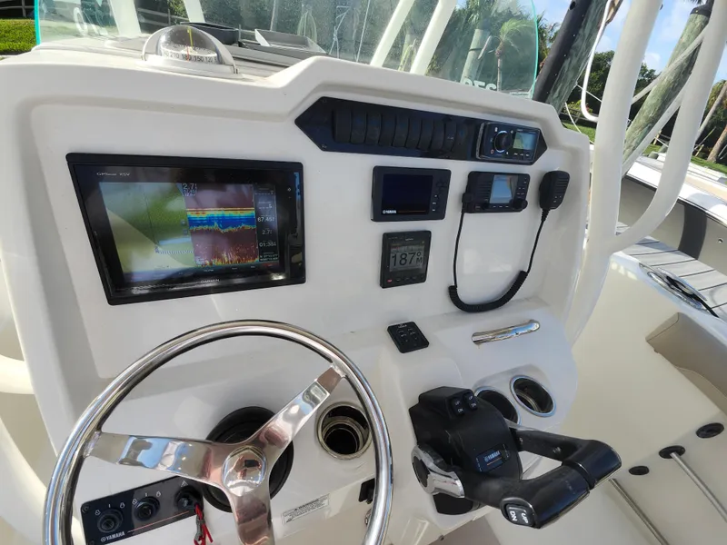 Slide: The Image of 2018 Sailfish 270 CC boat dashboard with steering wheel and electronic controls. - 10