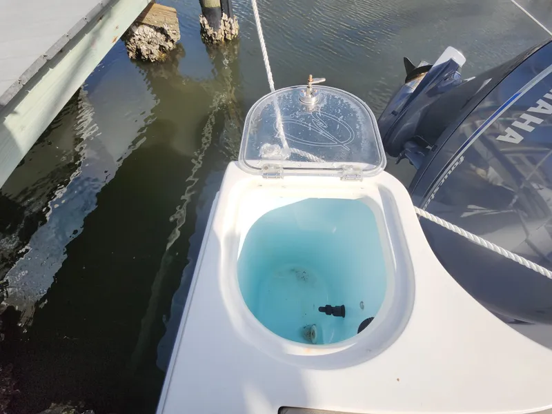 Slide: The Image of Livewell on 2018 Sailfish 270 CC boat, docked with Yamaha engine visible. - 21