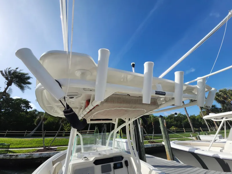 Slide: The Image of 2018 Sailfish 270 CC boat with rod holders, docked under clear blue sky. - 22