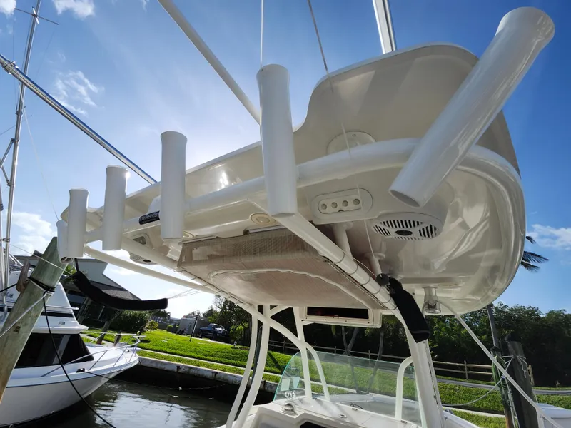 Slide: The Image of 2018 Sailfish 270 CC boat with rod holders, docked under clear blue sky. - 23