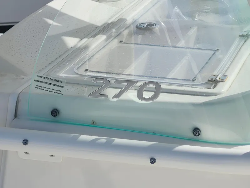 Slide: The Image of 2018 Sailfish 270 CC boat detail with clear windshield and sleek design. - 28