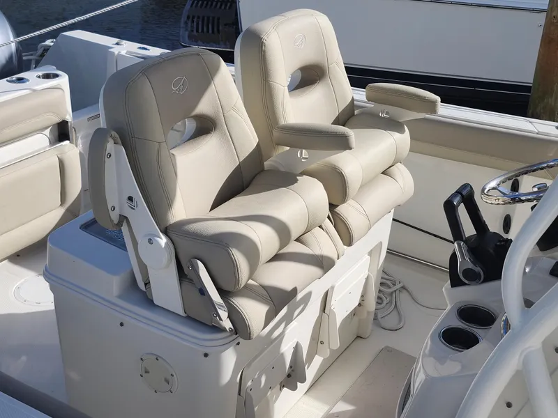Slide: The Image of 2018 Sailfish 270 CC boat with beige cushioned seats and armrests. - 6