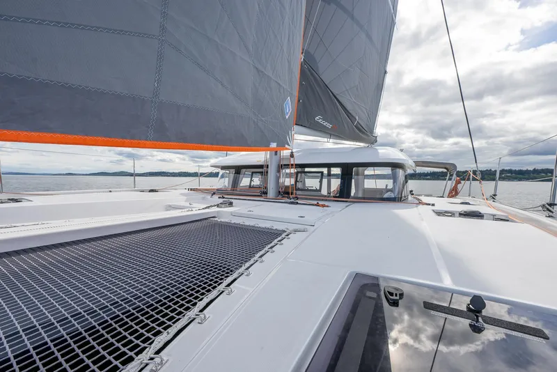 Slide: The Image of 2025 Excess 11 catamaran sailing on open water under cloudy skies. - 14