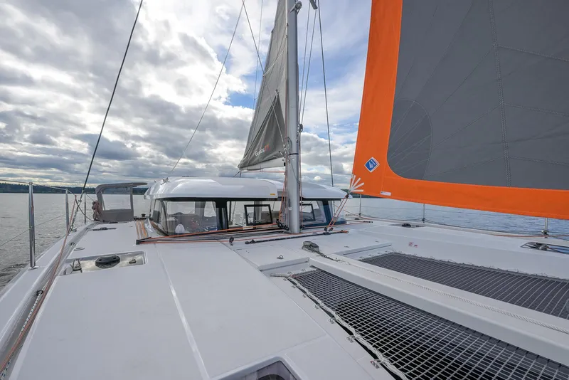 Slide: The Image of 2025 Excess 11 catamaran sailing on open water under cloudy skies. - 15