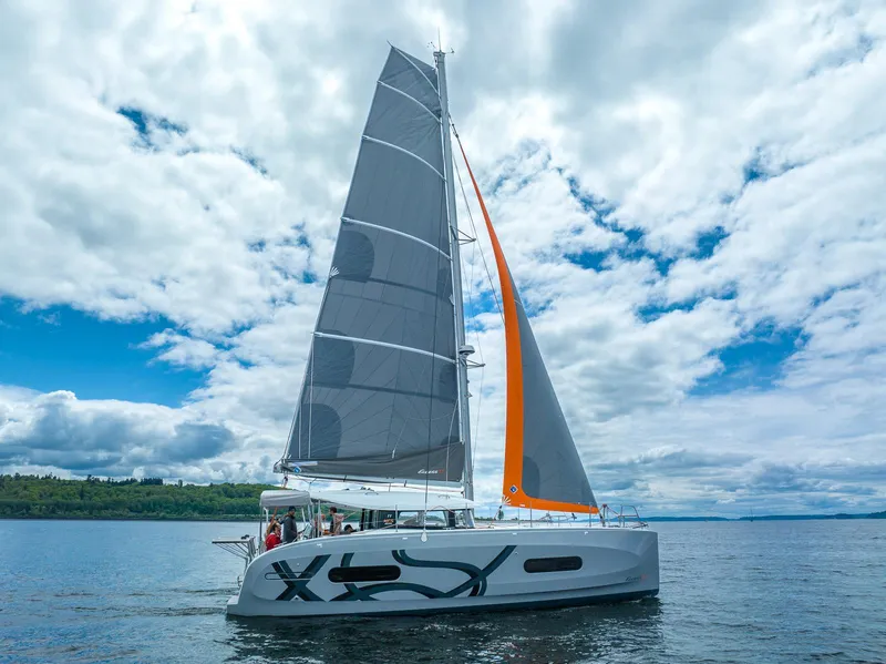 Slide: The Image of 2025 Excess 11 sailboat on open water under a partly cloudy sky. - 8