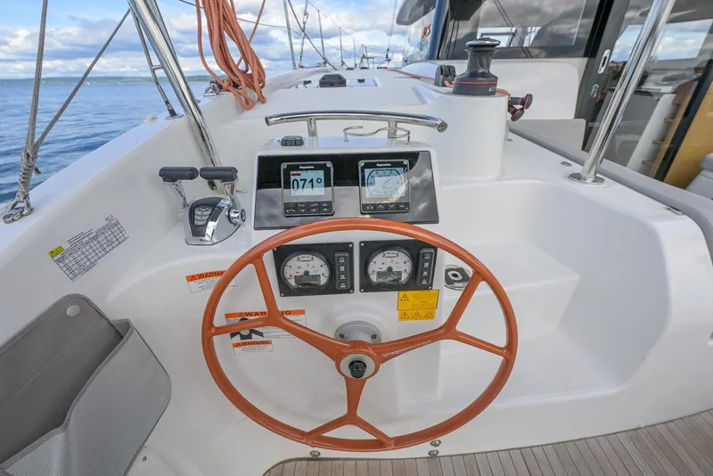 Slide: The Image of Steering wheel and controls of 2025 Excess 11 sailboat, featuring modern navigation instruments. - 9