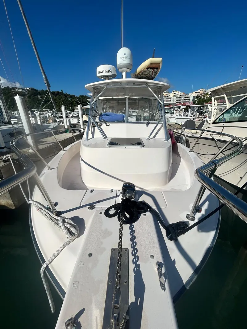 Slide: The Image of 2005 Grady-White Marlin 300 boat docked at marina under clear blue sky. - 12