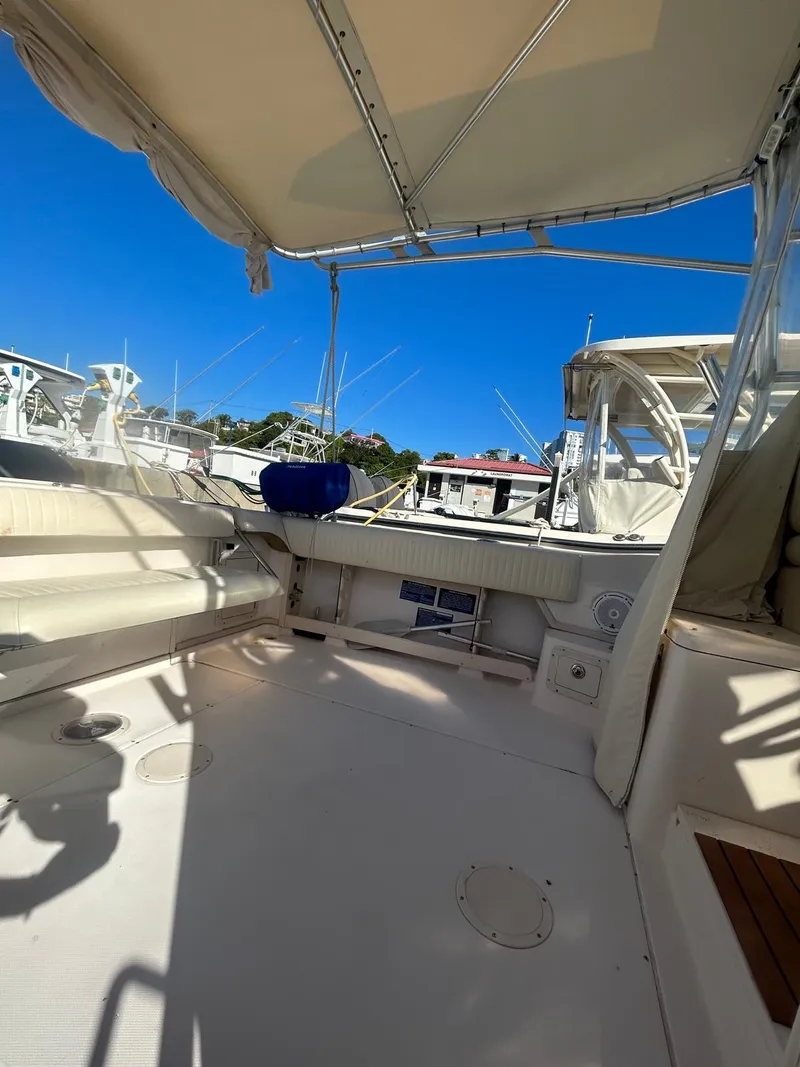 Slide: The Image of 2005 Grady-White Marlin 300 boat interior with canopy, docked under clear blue sky. - 7