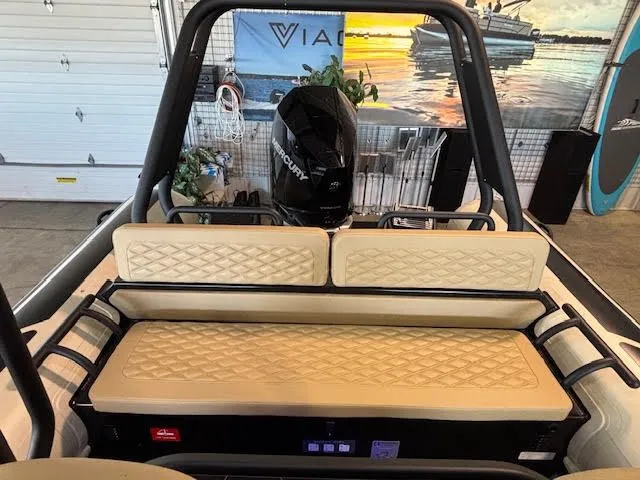 Slide: The Image of 2025 Highfield Sport 700 boat interior with beige seating and Mercury engine in a showroom. - 19