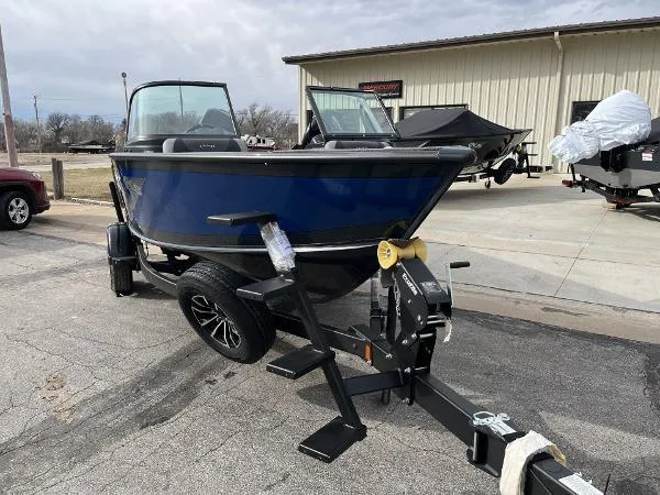 Slide: The Image of 2025 Lund 1875 Crossover XS boat on trailer, parked outdoors. - 4