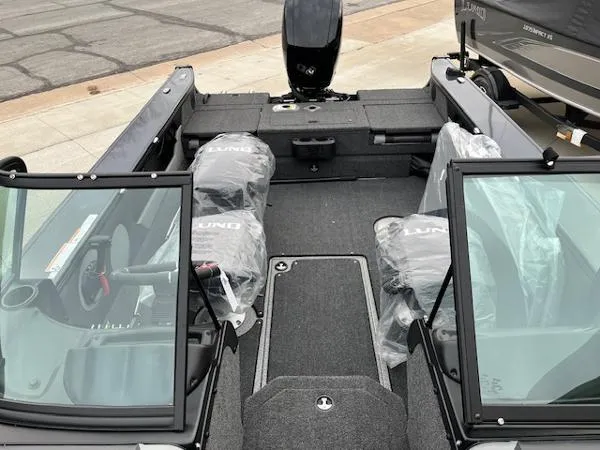 Slide: The Image of 2025 Lund 1875 Crossover XS boat interior with protective covers and windshield. - 6