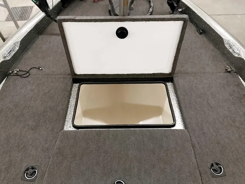 Slide: The Image of 1999 Ranger 461VS Comanche boat storage compartment with open lid, gray carpeted interior. - 16