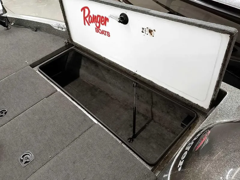 Slide: The Image of Open storage compartment in a 1999 Ranger 461VS Comanche boat, featuring carpeted interior. - 17
