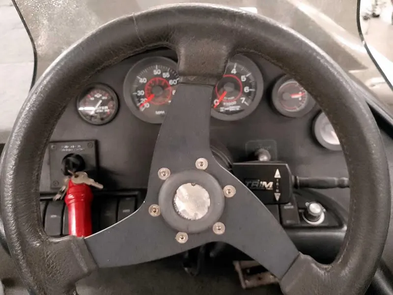 Slide: The Image of Steering wheel and dashboard of a 1999 Ranger 461VS Comanche boat. - 26