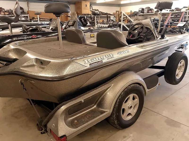 Slide: The Image of 1999 Ranger 461VS Comanche boat in a garage, showcasing sleek design and trailer. - 34