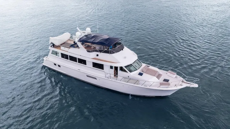 Slide: The Image of 1998 Hatteras 74 Sport Deck Motor Yacht cruising on open water. - 10