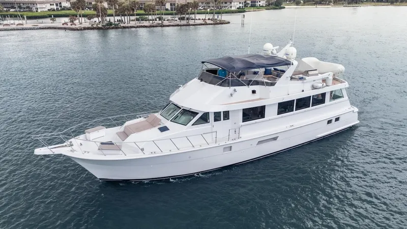 Slide: The Image of 1998 Hatteras 74 Sport Deck Motor Yacht cruising on calm waters. - 16