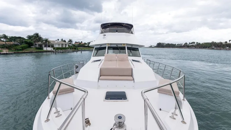 Slide: The Image of 1998 Hatteras 74 Sport Deck Motor Yacht on calm water, featuring spacious deck and seating. - 17