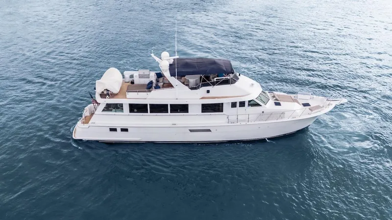 Slide: The Image of 1998 Hatteras 74 Sport Deck Motor Yacht cruising on open water. - 2
