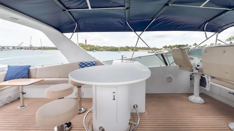 Slide: The Image of 1998 Hatteras 74 Sport Deck Motor Yacht with covered seating area and ocean view. - 20