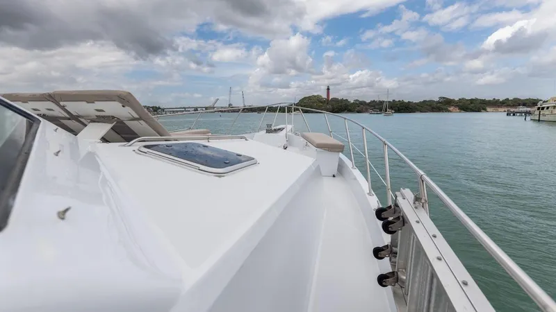 Slide: The Image of 1998 Hatteras 74 Sport Deck Motor Yacht on calm waters under a partly cloudy sky. - 21