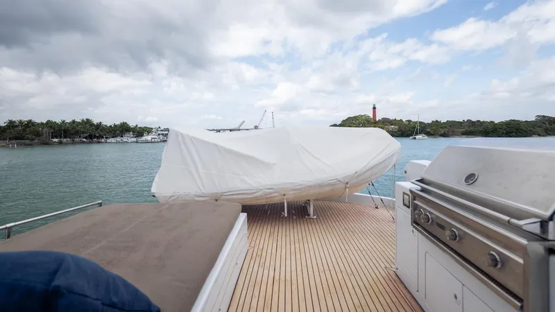 Slide: The Image of 1998 Hatteras 74 Sport Deck Motor Yacht with covered deck and grill, overlooking scenic waterway. - 23