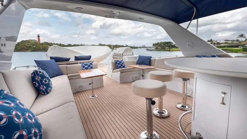 Slide: The Image of Luxurious 1998 Hatteras 74 Sport Deck Motor Yacht with elegant outdoor seating and scenic views. - 28