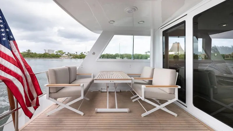 Slide: The Image of Outdoor seating area on 1998 Hatteras 74 Sport Deck Motor Yacht with American flag. - 33