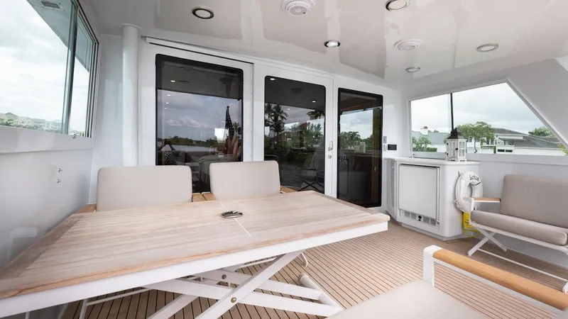 Slide: The Image of 1998 Hatteras 74 Sport Deck Motor Yacht interior with seating and table on deck. - 35