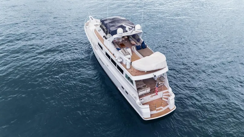 Slide: The Image of 1998 Hatteras 74 Sport Deck Motor Yacht cruising on open water. - 4