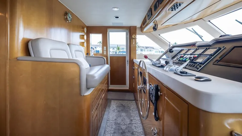 Slide: The Image of 1998 Hatteras 74 Sport Deck Motor Yacht helm with wooden interior and modern controls. - 44