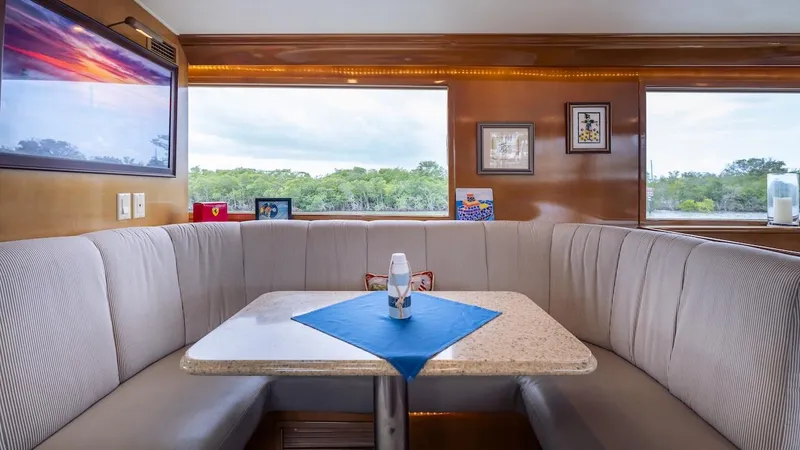 Slide: The Image of Dining area in 1998 Hatteras 74 Sport Deck Motor Yacht with large windows and cozy seating. - 46