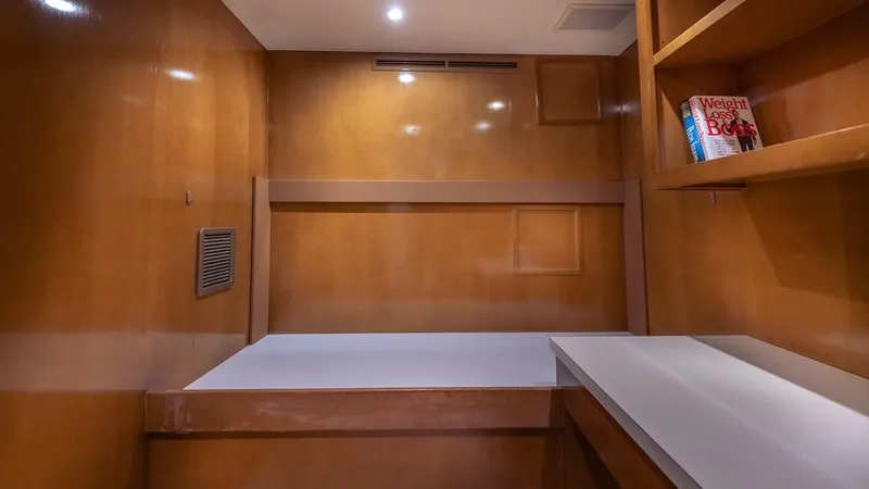 Slide: The Image of 1998 Hatteras 74 Sport Deck Motor Yacht interior with wooden finish and built-in shelving. - 47
