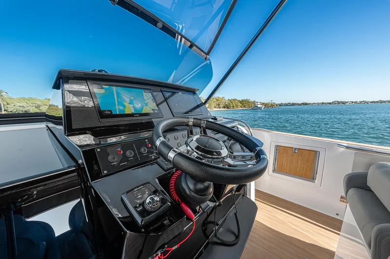 Slide: The Image of Helm of 2023 Pardo Yachts P38 with navigation screen, steering wheel, and ocean view. - 45