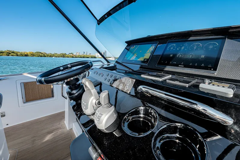 Slide: The Image of 2023 Pardo Yachts P38 helm with modern controls and navigation screens, overlooking serene waters. - 49