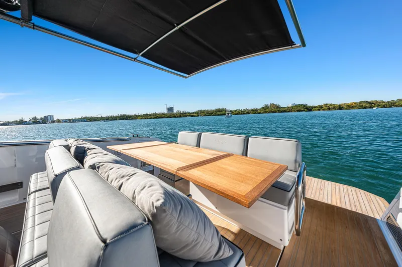 Slide: The Image of Luxurious 2023 Pardo Yachts P38 deck with seating, table, and scenic water view. - 39