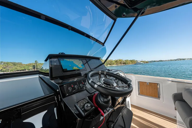 Slide: The Image of 2023 Pardo Yachts P38 helm with navigation system, steering wheel, and scenic water view. - 42
