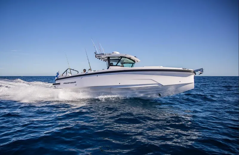 Slide: The Image of 2025 Axopar 29 CCX cruising on open water under clear blue skies. - 3