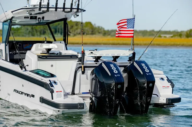Slide: The Image of 2025 Axopar 29 CCX boat with dual engines and American flag on water. - 5