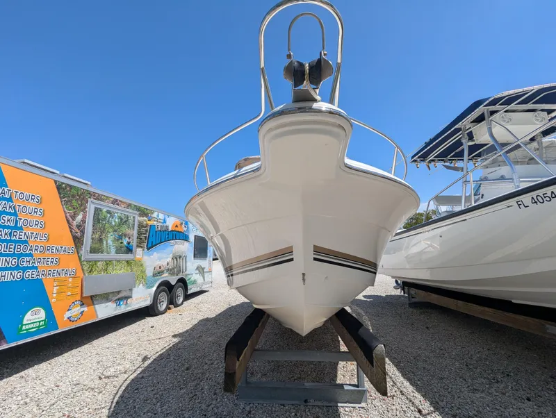 Slide: The Image of 2003 Wellcraft 210 Sportsman boat on trailer, parked outdoors under clear blue sky. - 2