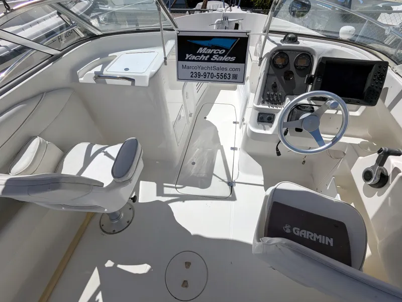 Slide: The Image of 2003 Wellcraft 210 Sportsman boat interior with Garmin equipment and yacht sales sign. - 8