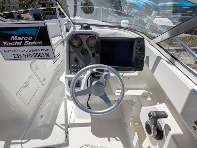 Slide: The Image of 2003 Wellcraft 210 Sportsman boat dashboard with steering wheel and navigation instruments. - 9